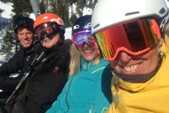 skiers smiling at the camera with rainbow visor